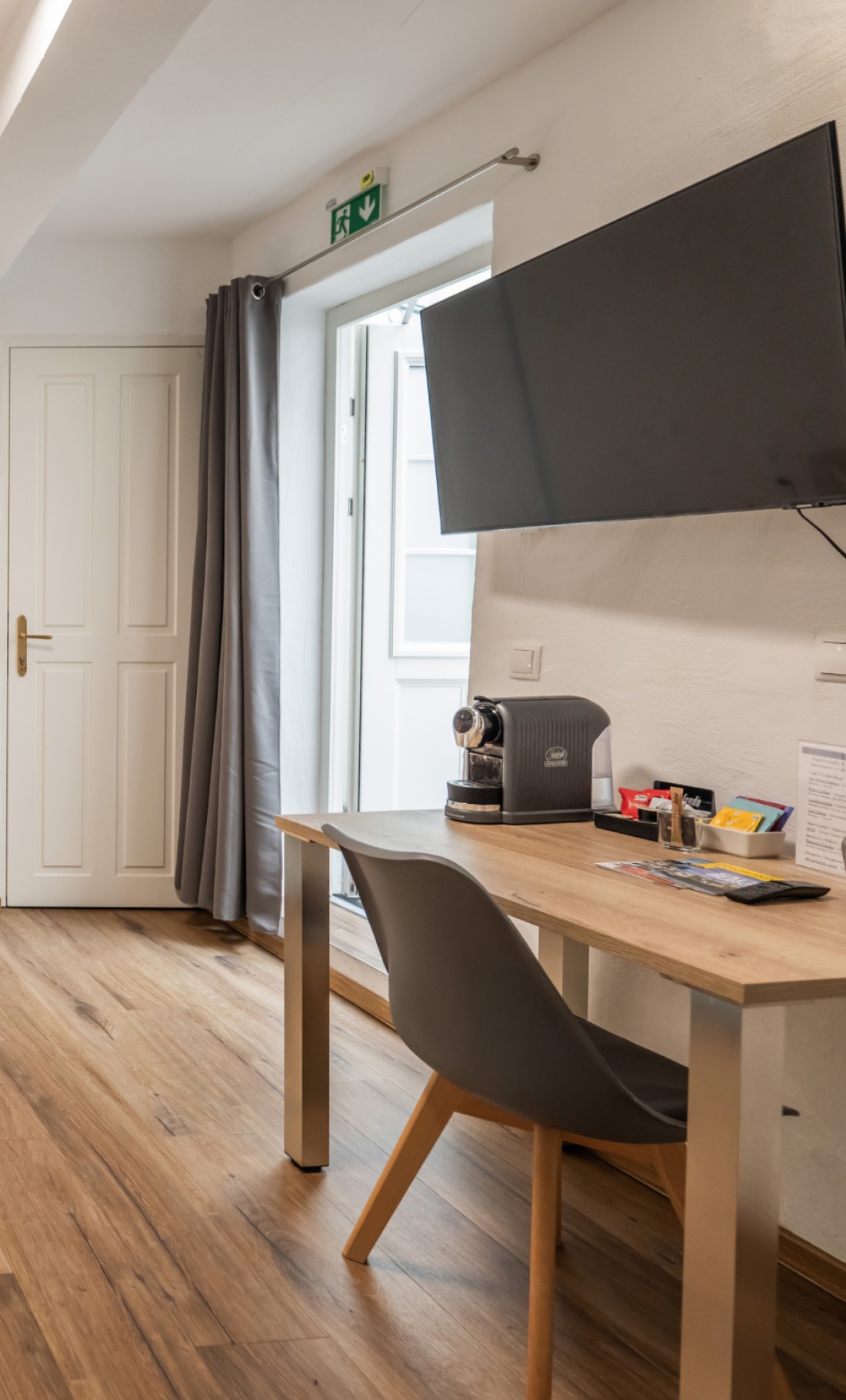 Schreibtisch mit Kaffeemaschine und TV im Economy Apartment