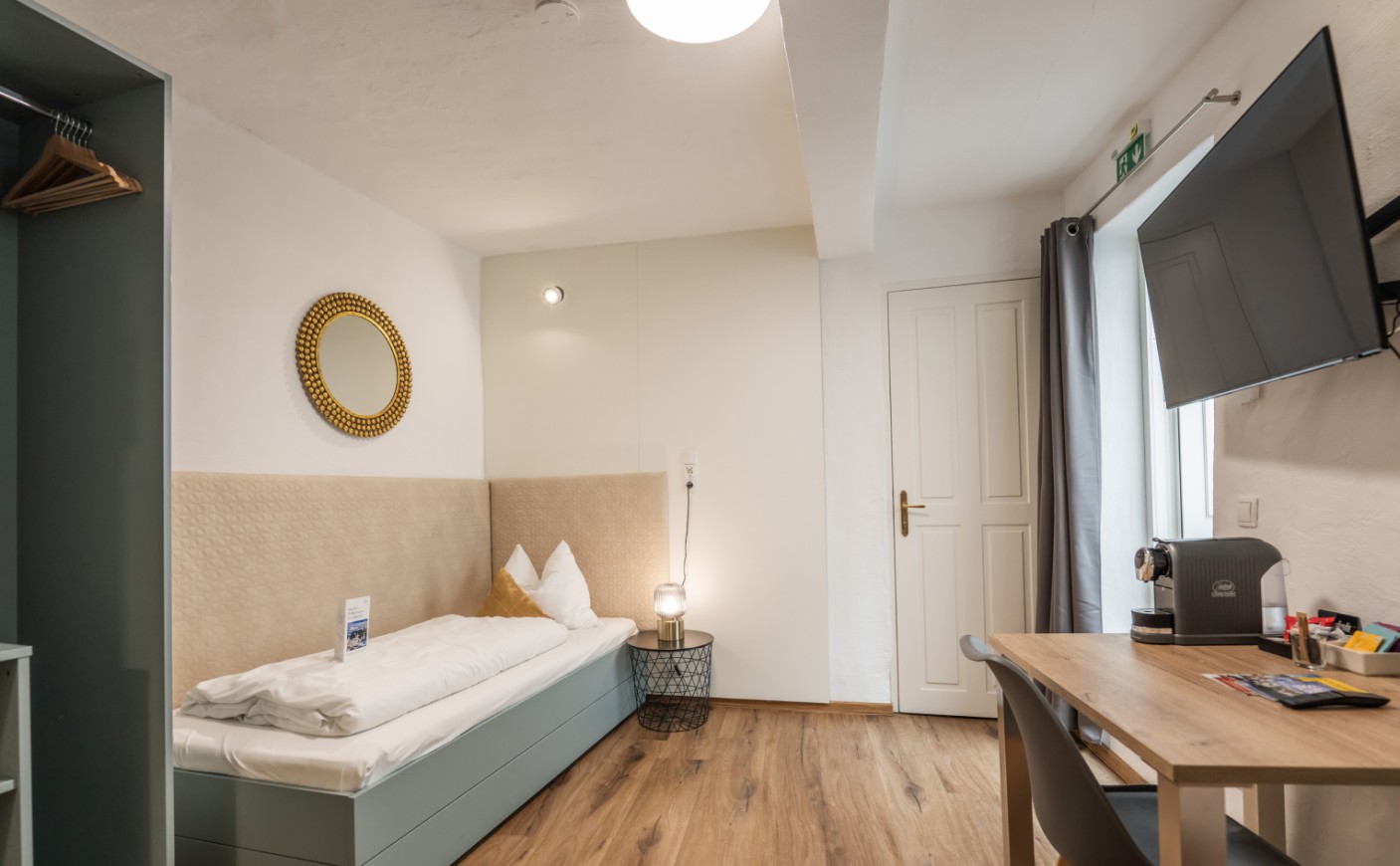 Helles Economy Apartment mit Einzelbett, Schreibtisch und TV