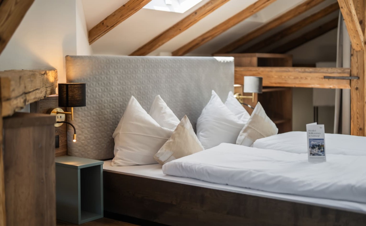 Schlafbereich mit Doppelbett und freiliegenden Holzbalken