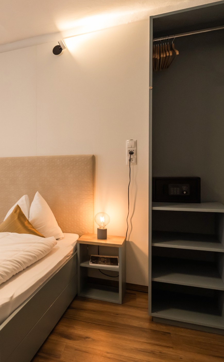 Schlafbereich mit offenem Kleiderschrank im Standard Apartment