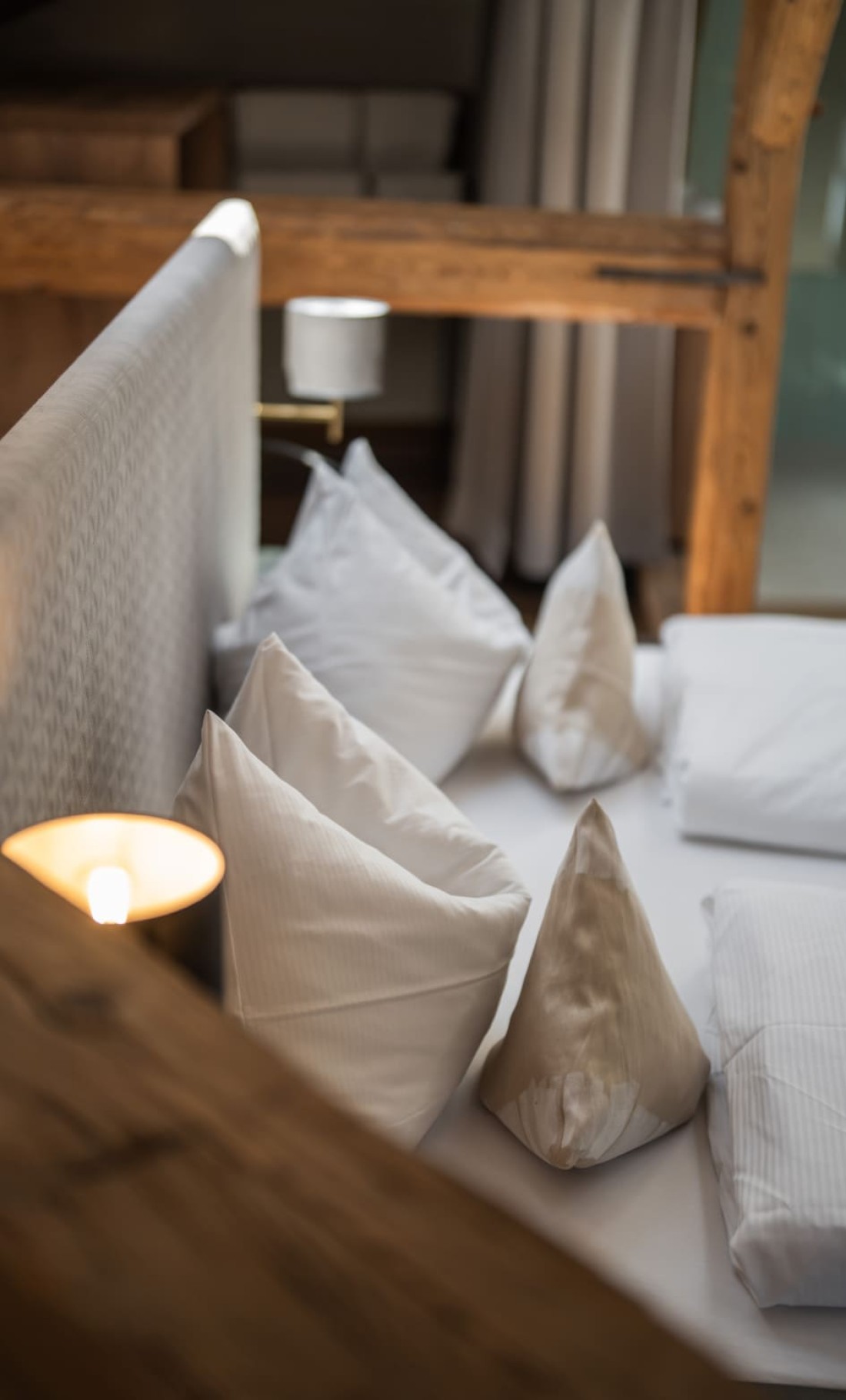 Gem&uuml;tliches Schlafzimmer mit Holzbalken, Dachfenster und modernem Bett